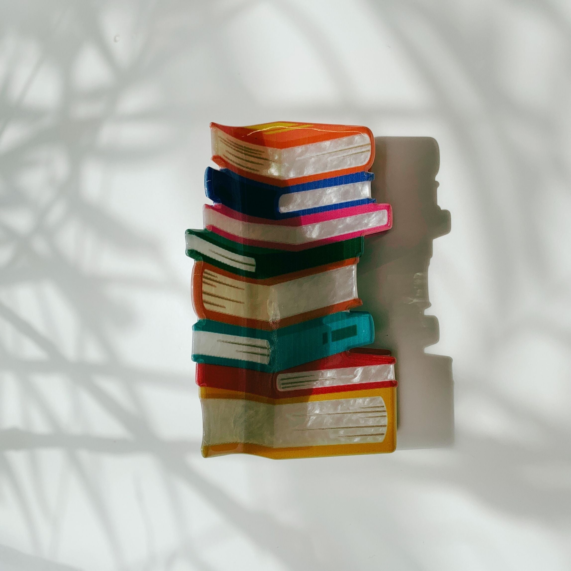 Velvet Claws Stack of Books hair clip from The Bullish Store, featuring a velvet claw design and travel bag for accessories.