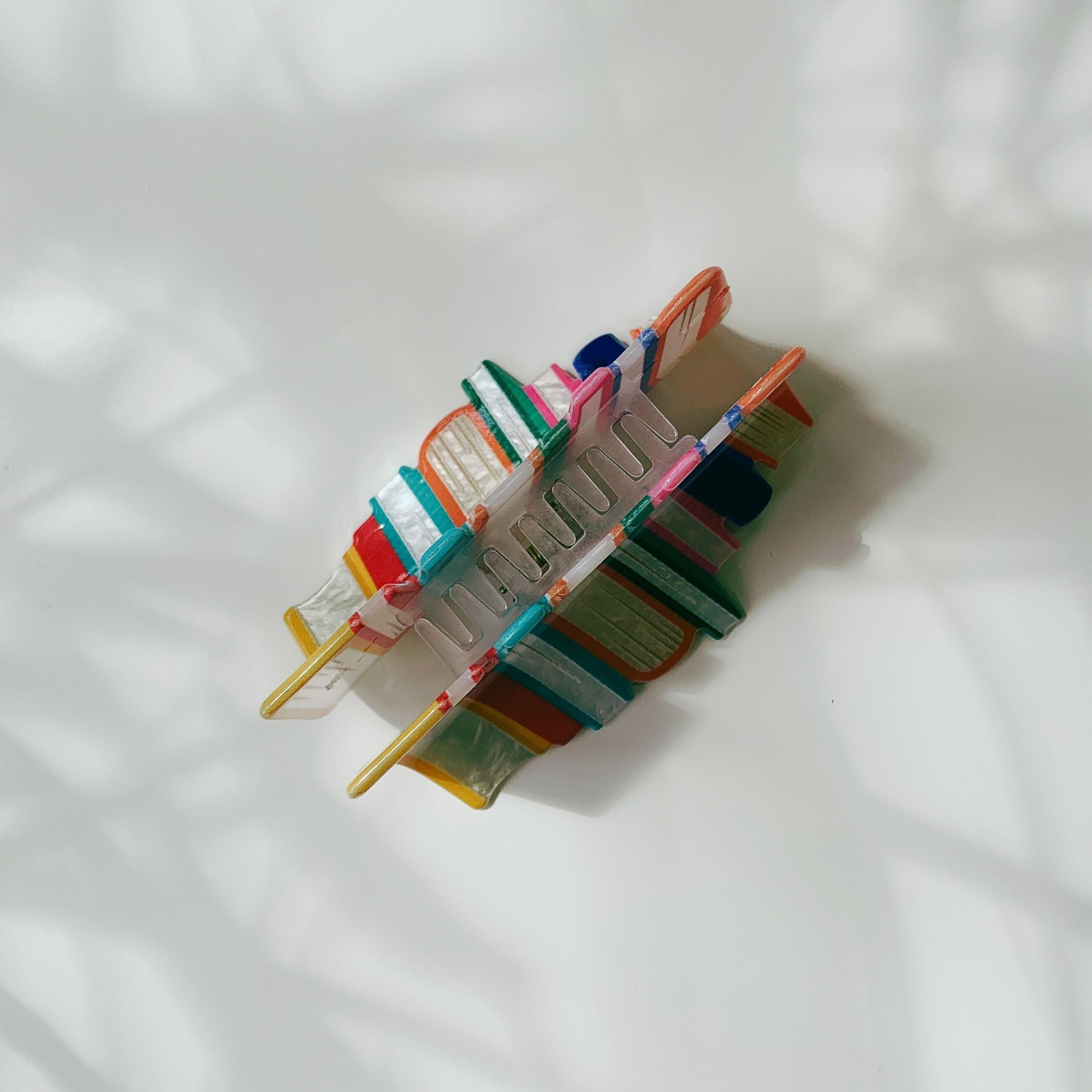 Velvet Claws stack of books hair clip by The Bullish Store featuring a plush velvet claw design in a travel bag.