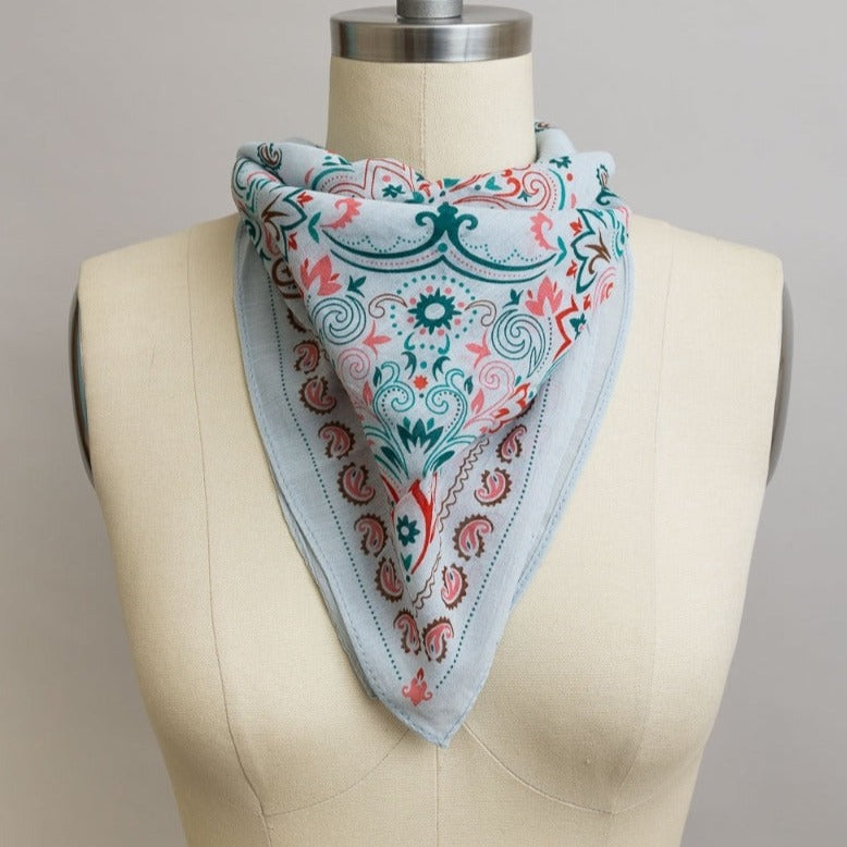 Teal vintage colorful paisley bandana from The Bullish Store, featuring intricate paisley patterns on a soft fabric necktie or headscarf.