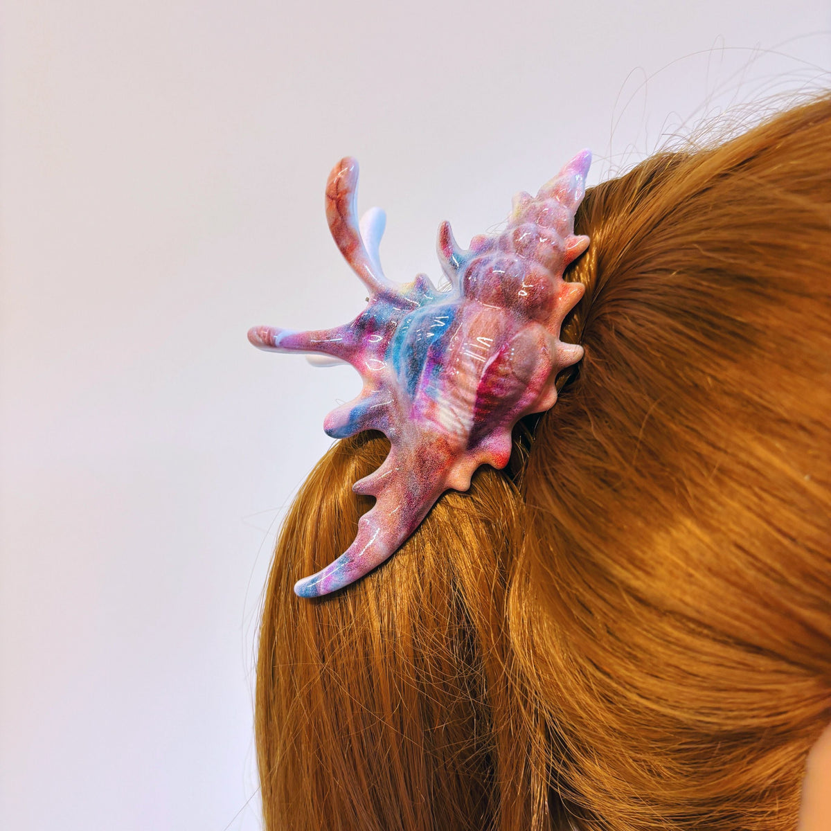 Velvet Claws realistic conch shell hair clip in vibrant mermaid colors, designed by The Bullish Store for stylish hair accessories.