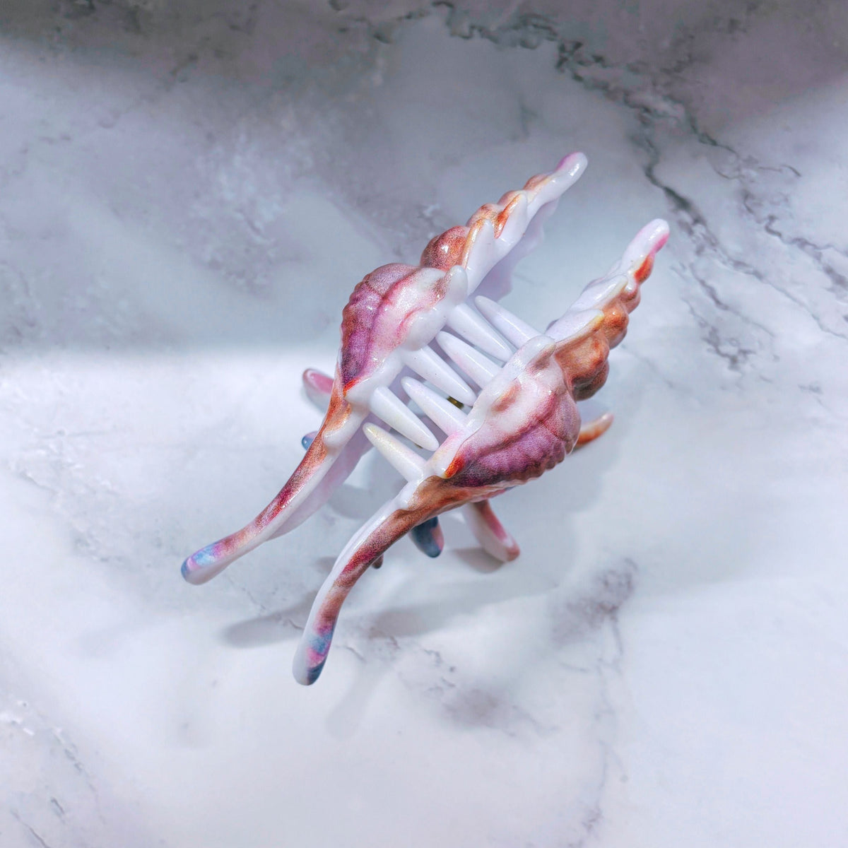 Velvet Claws realistic conch shell hair clip in mermaid colors, featuring a detailed, textured design for stylish hair accessories.