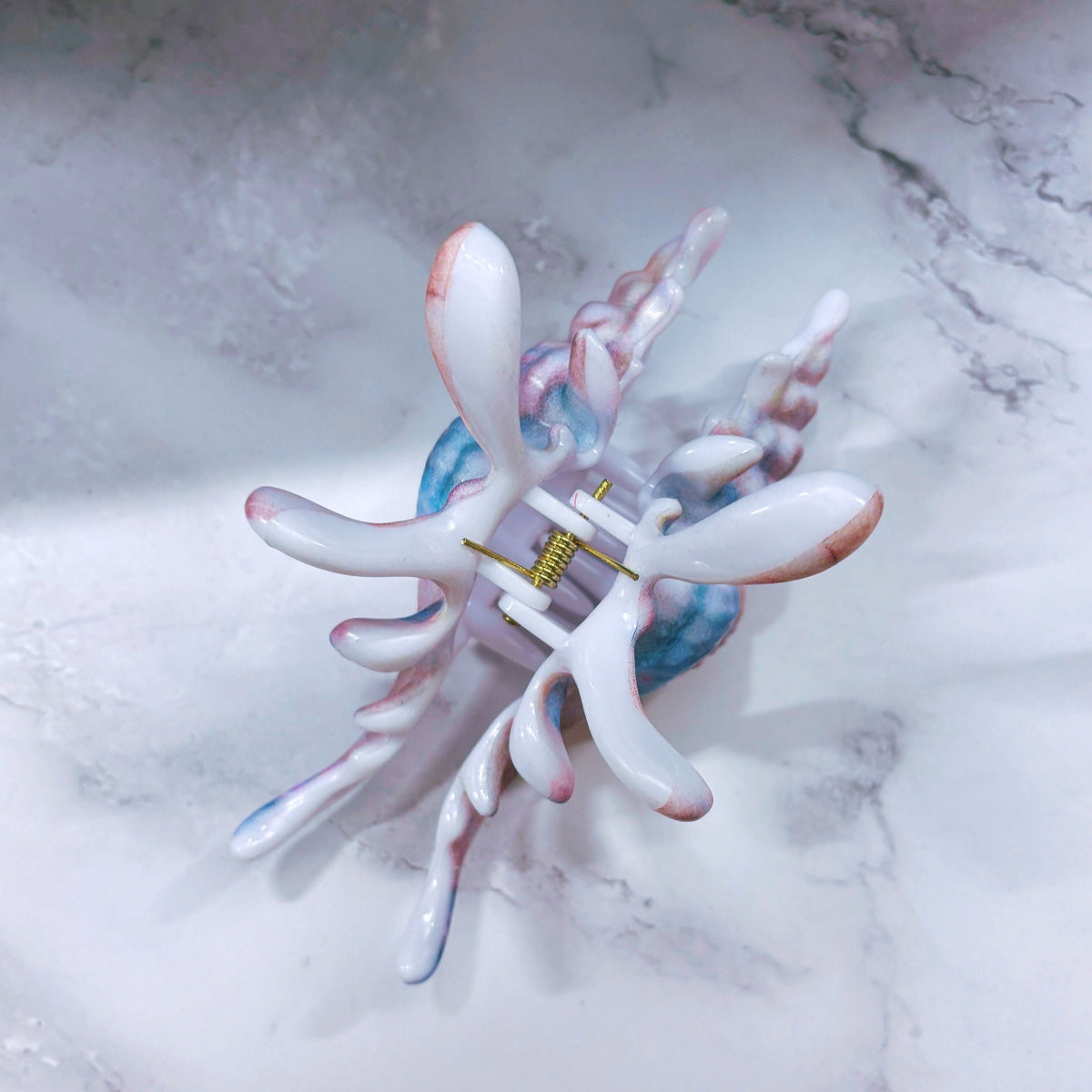 Velvet Claws real conch shell hair clip in vibrant mermaid colors, featuring a realistic design and a secure hair claw mechanism.