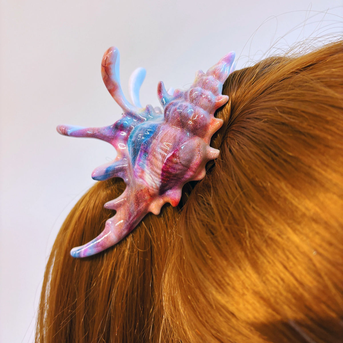 Velvet Claws realistic conch shell hair clip in vibrant mermaid colors, stylish and unique hair accessory.