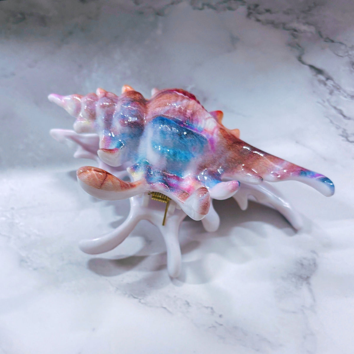 Velvet Claws realistic conch shell hair clip in vibrant mermaid colors, featuring a sleek, textured design for stylish hair styling.