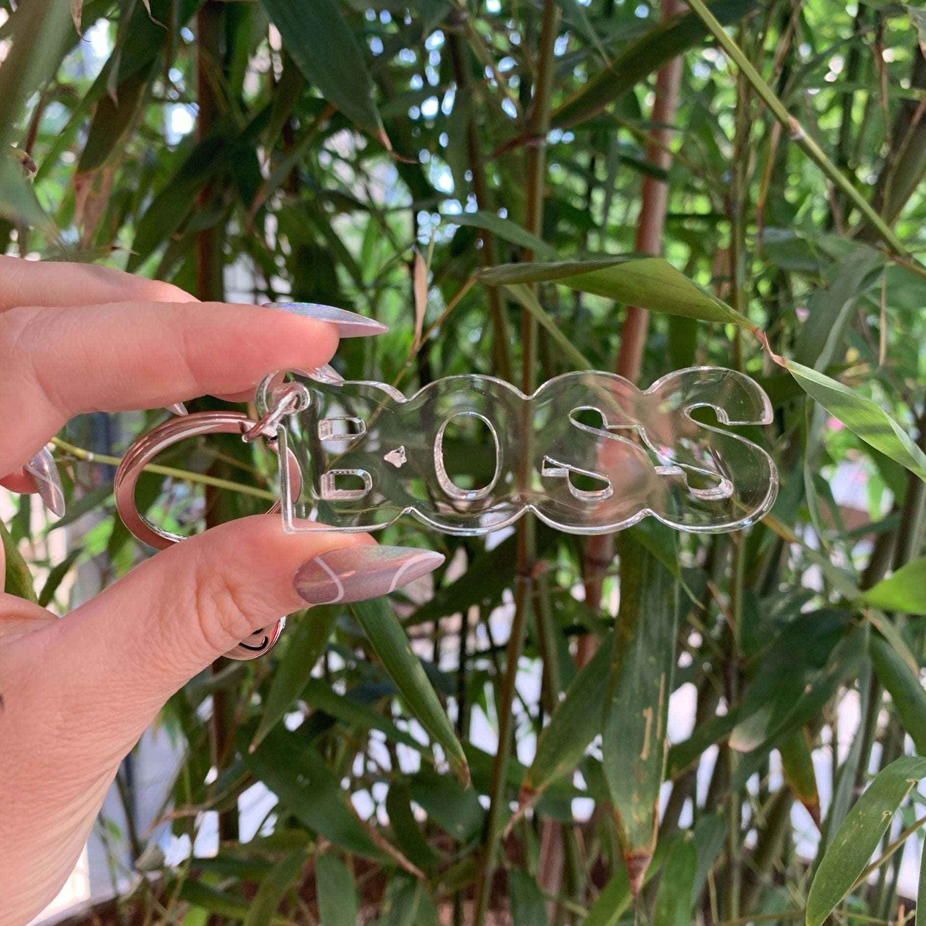 Clear acrylic Boss word keychain from The Bullish Store, transparent and word-shaped keyholder with a sleek, modern design.