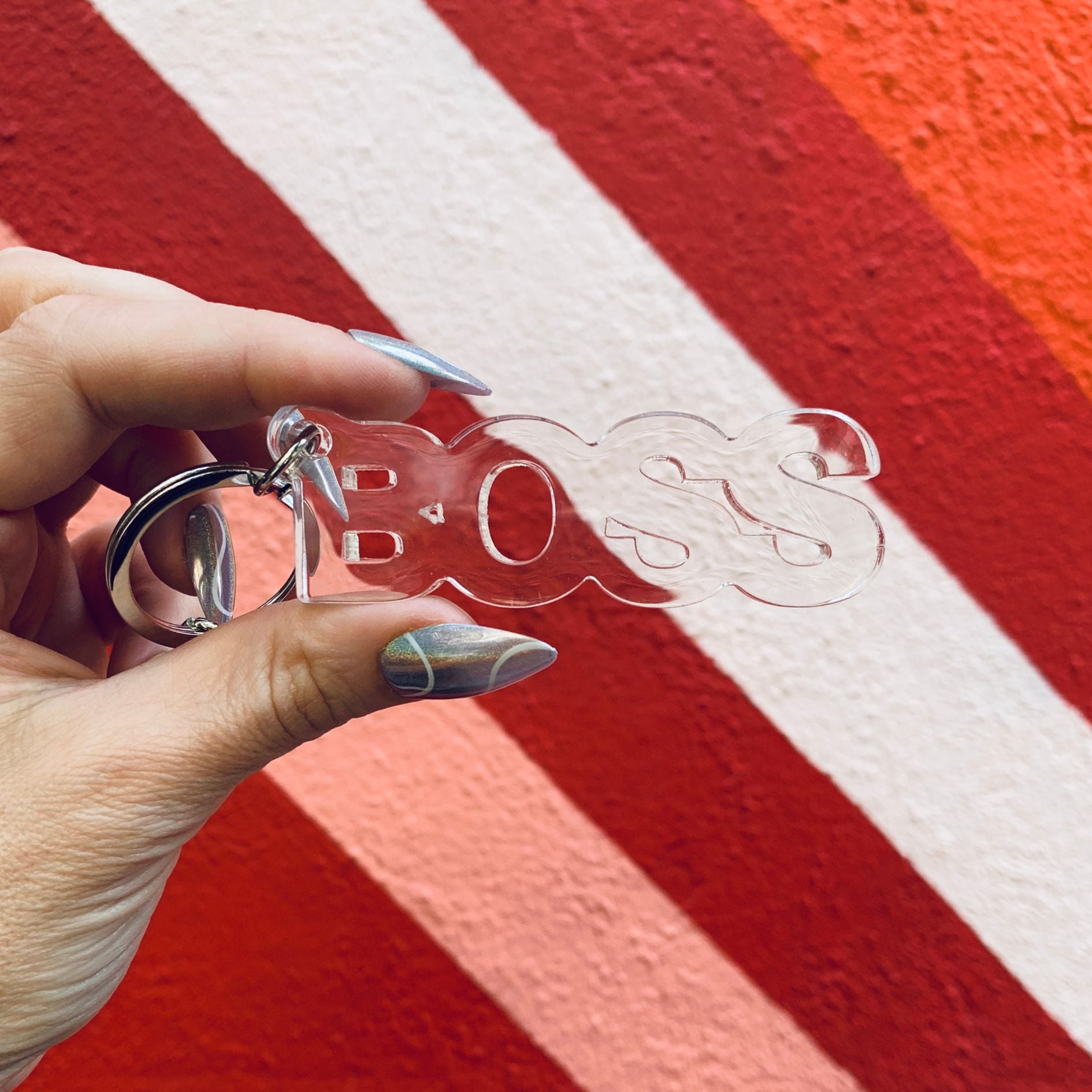 Clear acrylic Boss word keychain from The Bullish Store, transparent and word-shaped keyholder with a modern design.