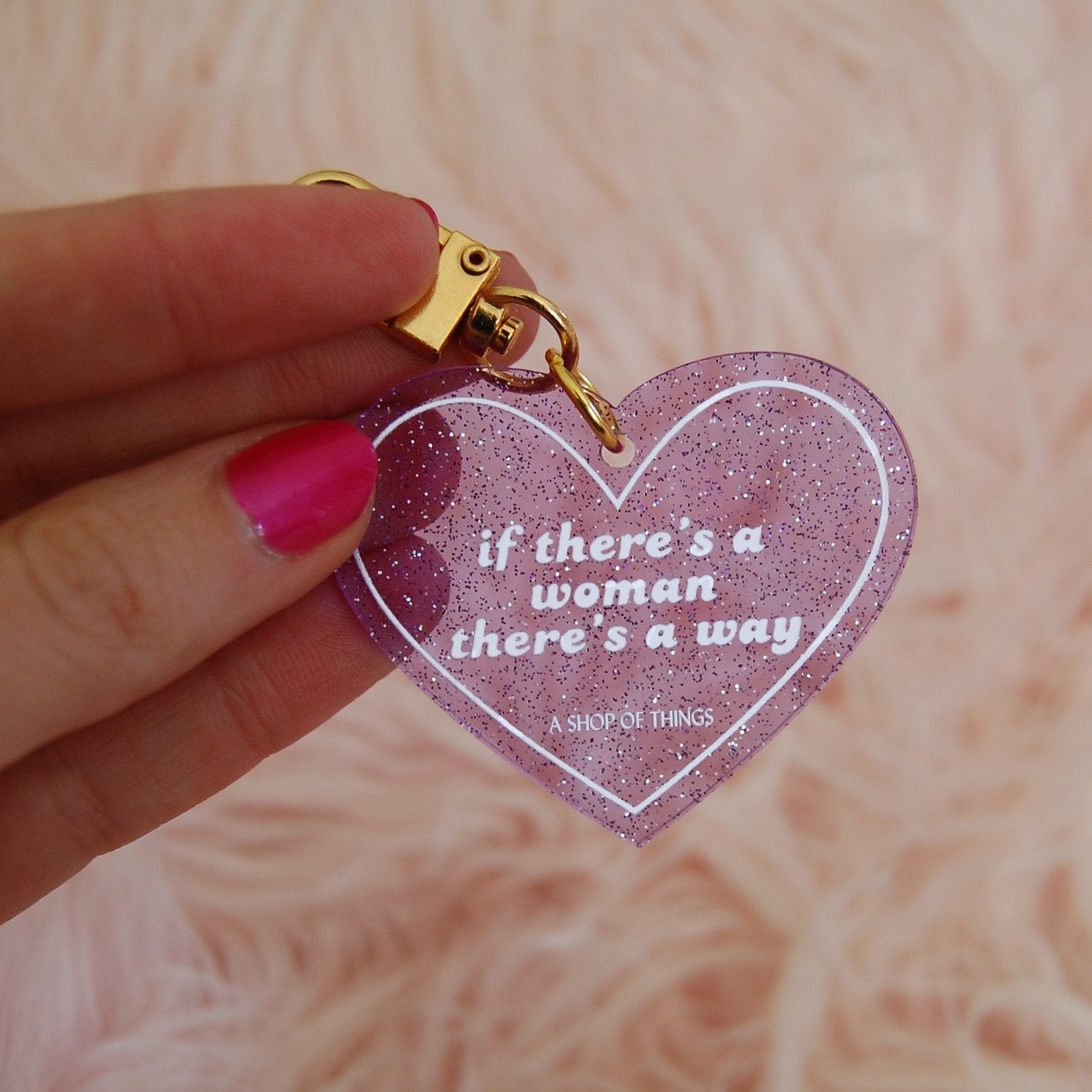 Heart-shaped keychain from The Bullish Store with "If There's A Woman There's A Way" engraved, featuring a silver finish.