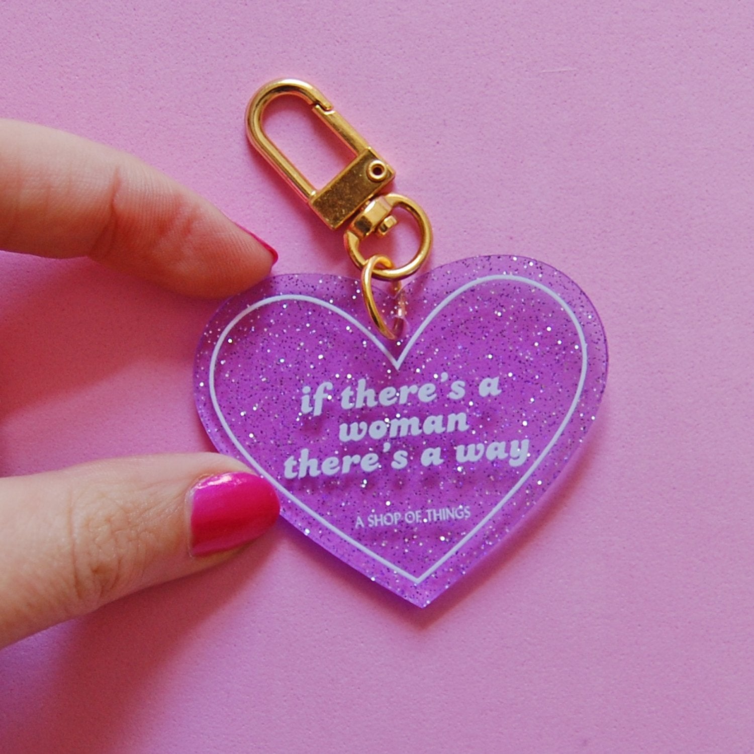 Heart-shaped keychain with "If There's A Woman There's A Way" phrase, from The Bullish Store, featuring a decorative design.