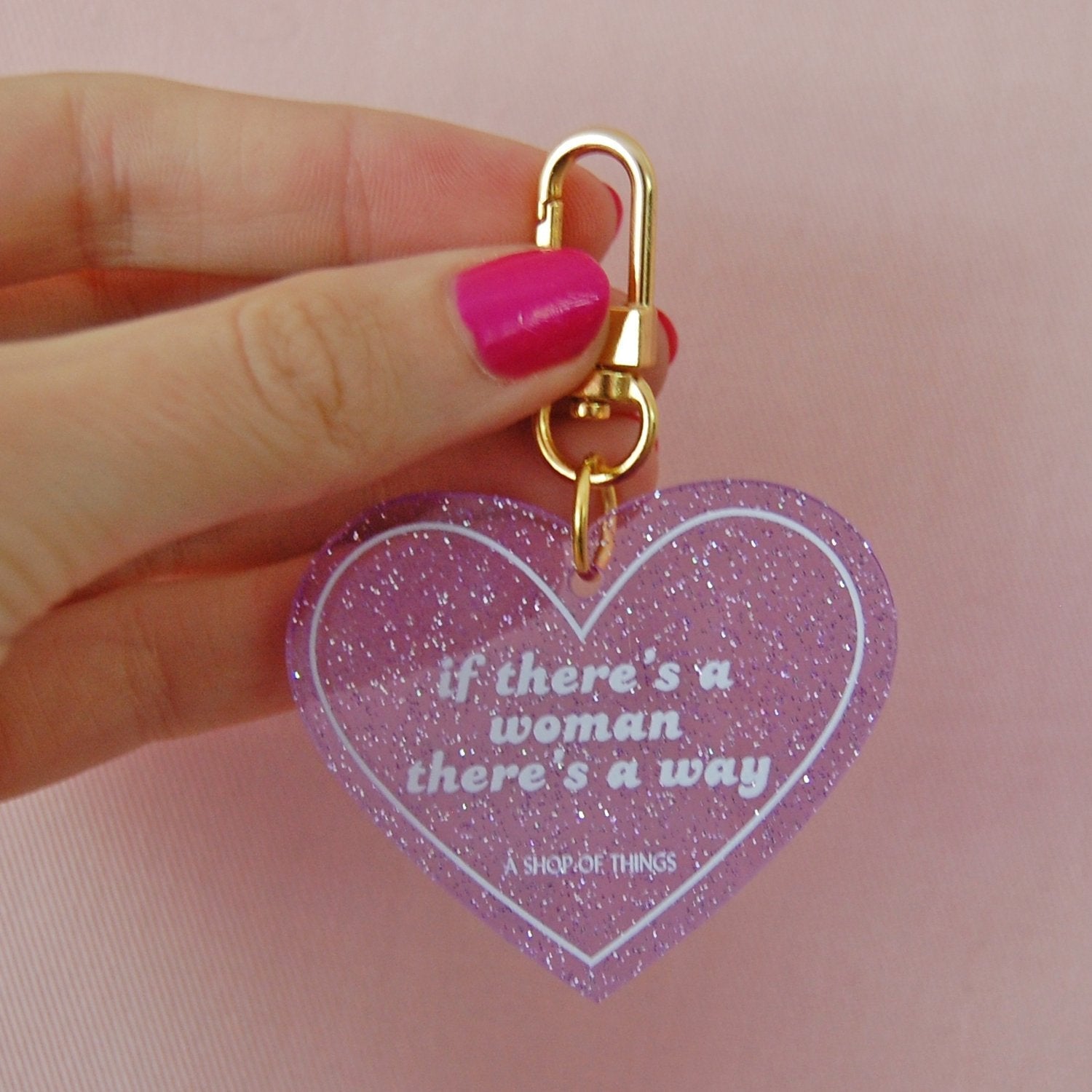 Heart-shaped keychain with "If There's A Woman There's A Way" slogan from The Bullish Store, featuring a colorful design.