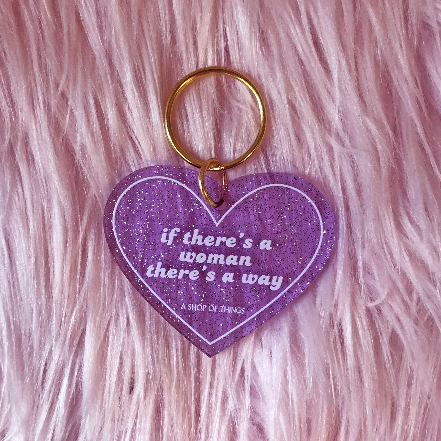 Heart-shaped keychain with motivational message from The Bullish Store, featuring a woman-themed design and decorative details.