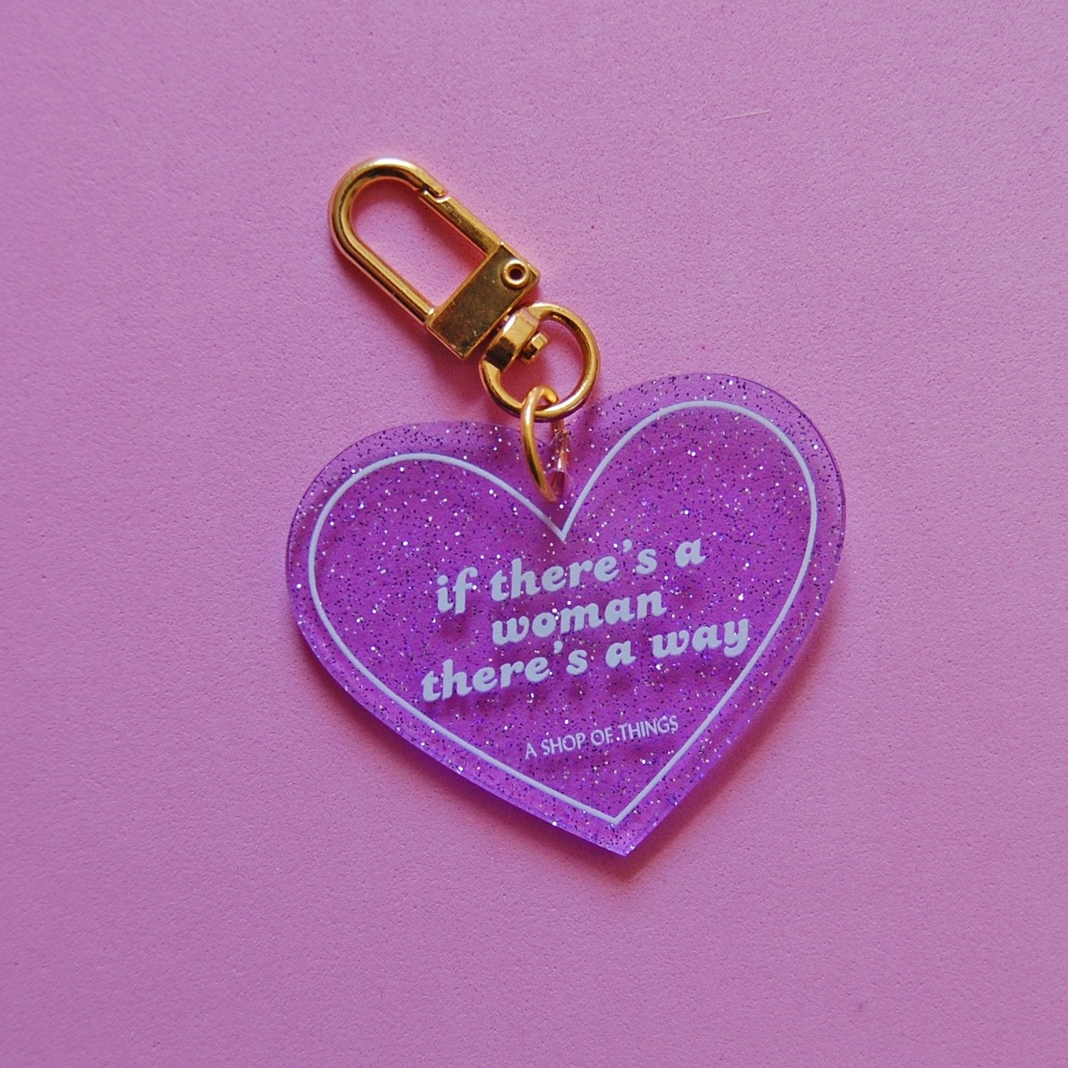 Heart-shaped keychain from The Bullish Store with the phrase "If There's A Woman There's A Way" engraved on it.
