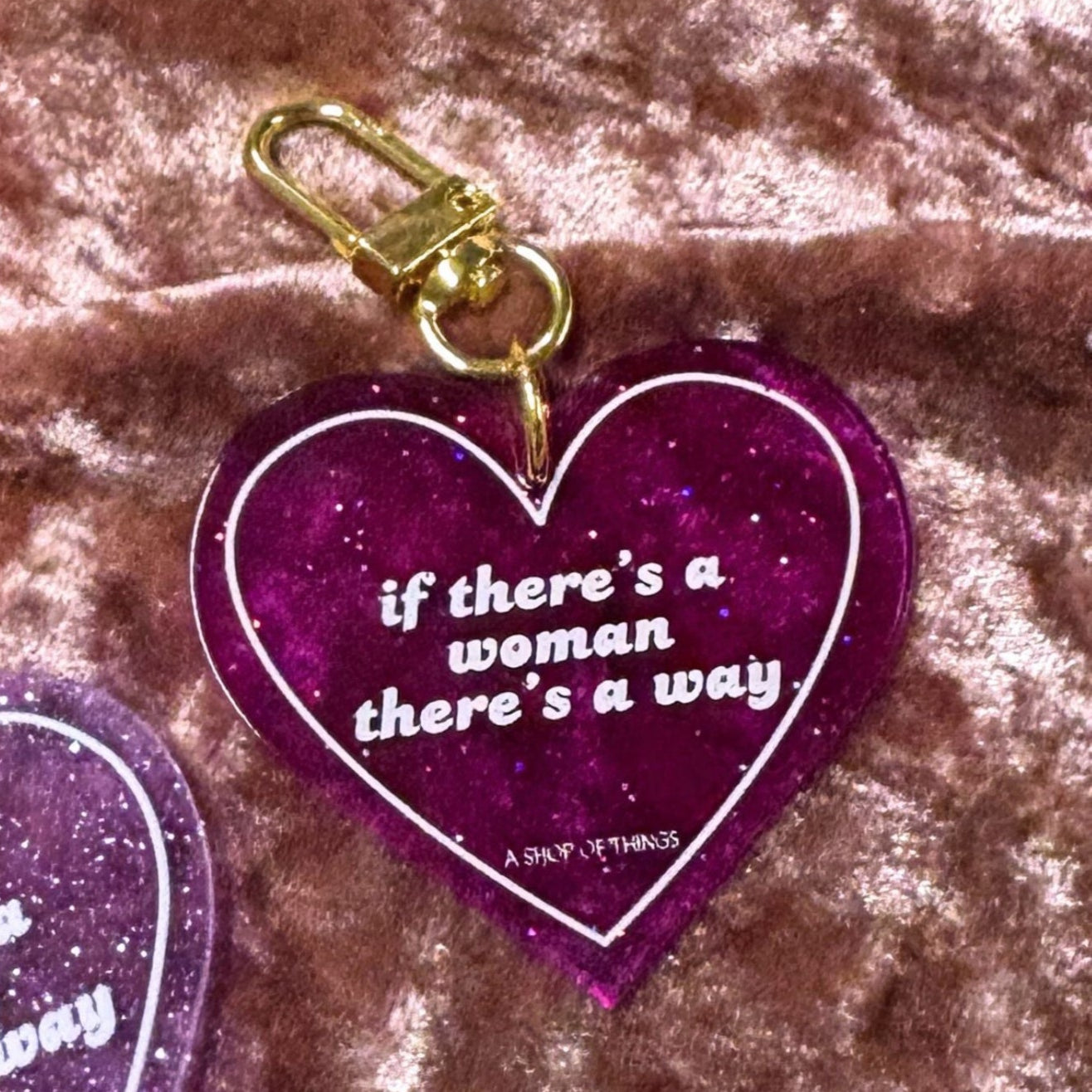 Heart-shaped keychain with "If There's A Woman There's A Way" inscription, from The Bullish Store, featuring a detailed design.