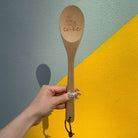 Marie Antoinette inspired wooden cooking spoon from The Bullish Store, displayed in muslin gift bag with playful sayings.