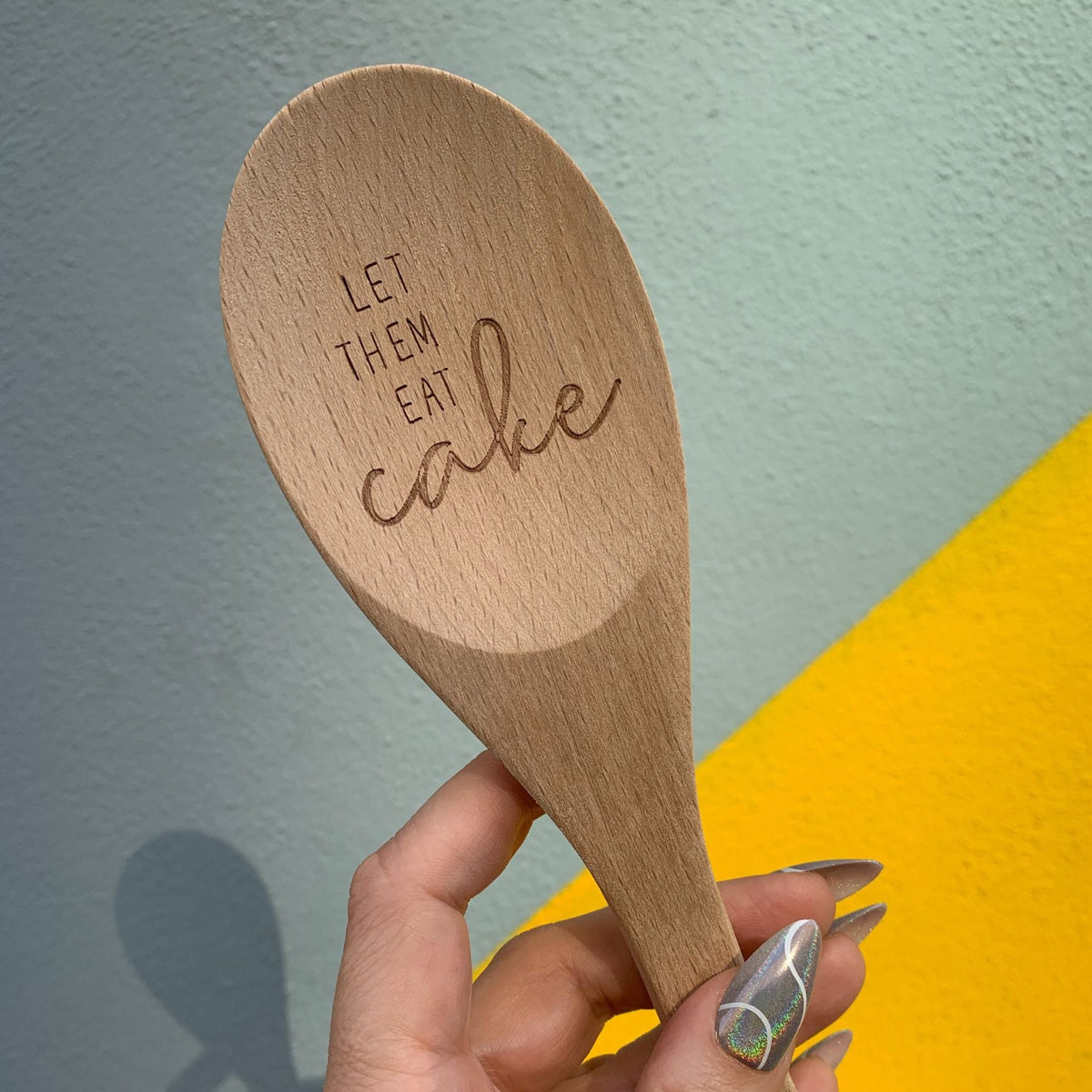 Marie Antoinette inspired wooden cooking spoon from The Bullish Store in a muslin gift bag, featuring a charming saying.