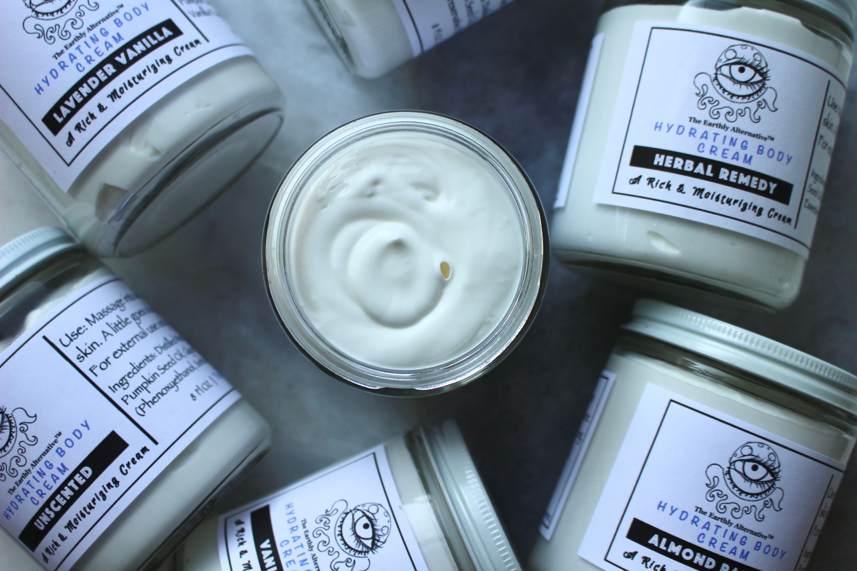 The Earthly Alternative almond-scented hydrating body cream in a jar, showcasing smooth cream and natural ingredients.