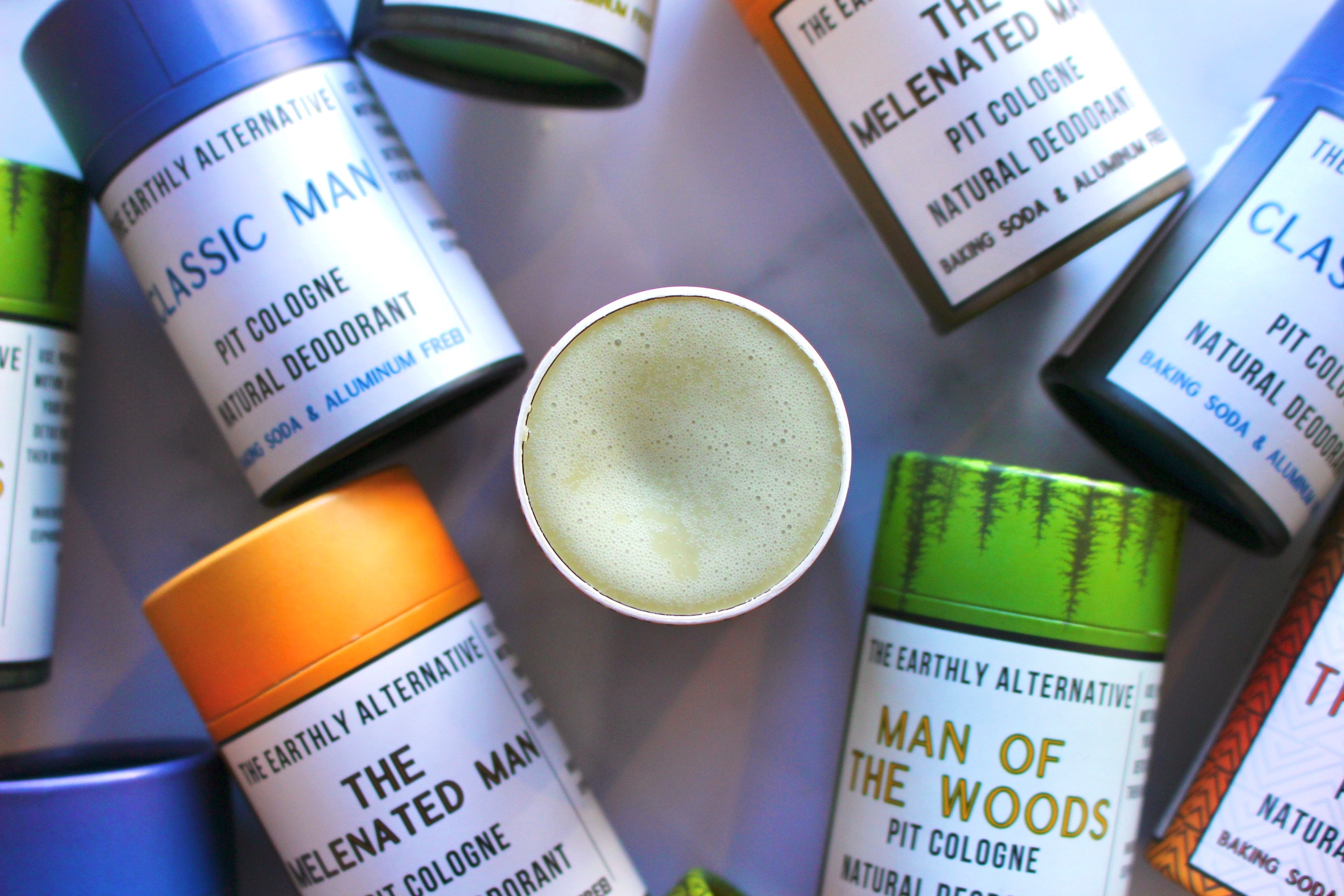 The Earthly Alternative Pit Cologne Deodorant for men, featuring a sleek container and natural scent, in a minimalistic design.