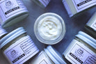 Natural beard balm by The Earthly Alternative in a tin container, with a smooth, creamy texture for beard grooming and conditioning.