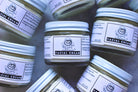 Cream jar labeled "Facial Cream" from The Earthly Alternative with a sleek, minimalist design on a neutral background.
