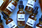 The Earthly Alternative Hair Growth Serum bottle with dropper, showing a clear liquid inside and natural branding on the label.