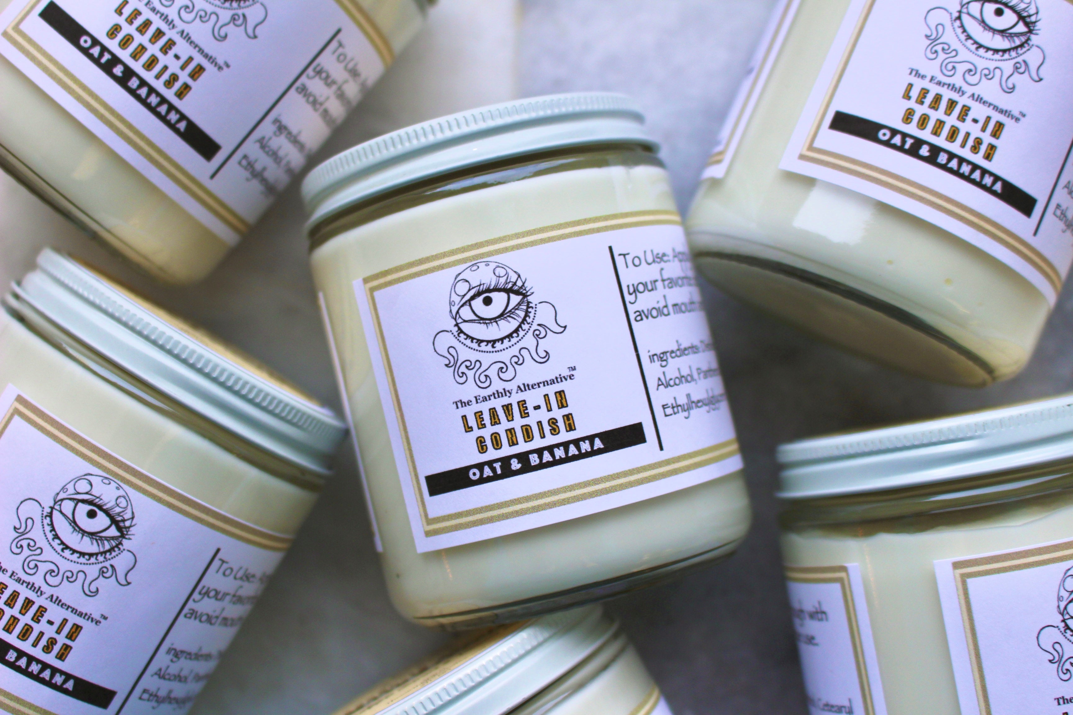 Oat and banana leave-in conditioner from The Earthly Alternative in a clear bottle with a pump dispenser.