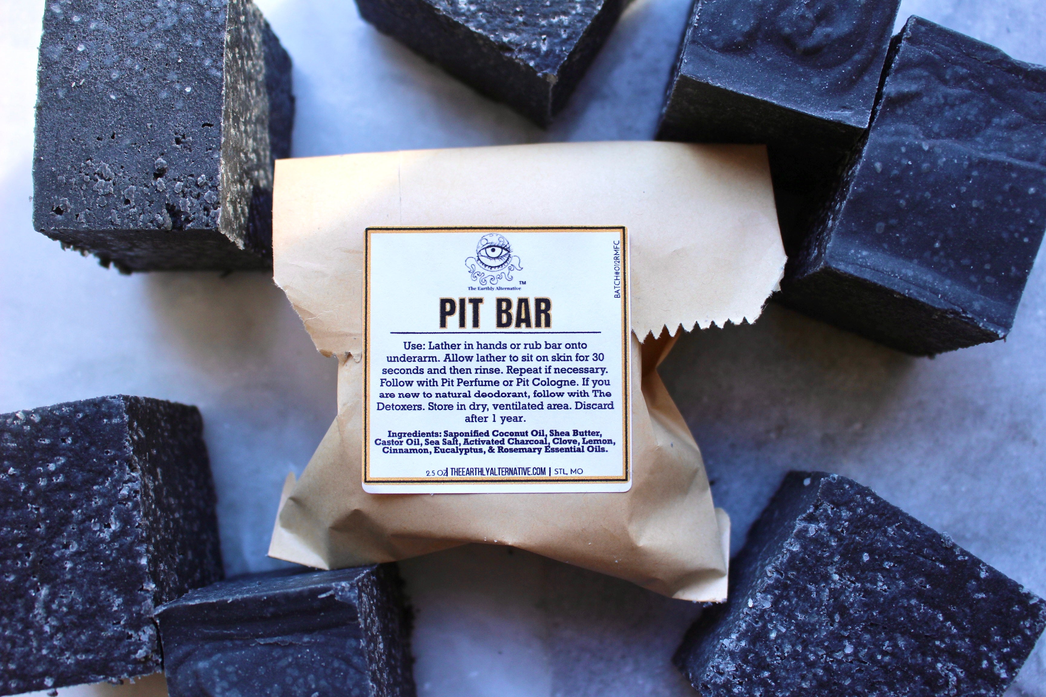 The Earthly Alternative Pit Bar, a sturdy metal tool with a wooden handle for lifting and moving hot coals or pits.