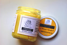 Turmeric Face and Body Scrub by The Earthly Alternative showing the jar with turmeric-colored scrub inside