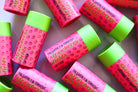 The Earthly Alternative Fluffy Mallow Lip Balm with a smooth, creamy texture in a clear container, designed to moisturize lips.