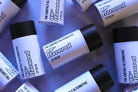 The Earthly Alternative Fluffy Mallow Lip Balm in a small jar with a pastel pink lid, featuring a soft, creamy texture.