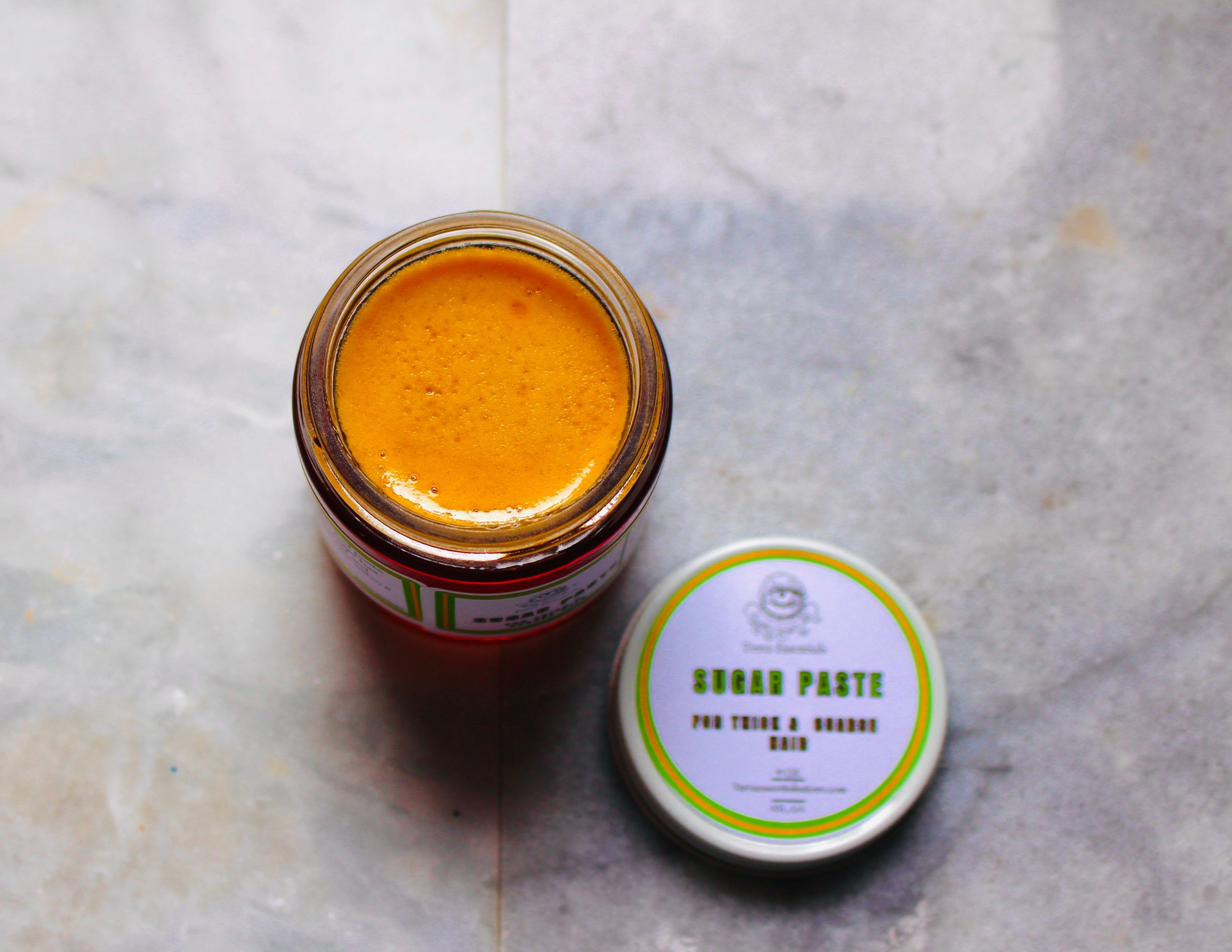 Creamy sugar paste by The Earthly Alternative for hair removal, shown in a natural, smooth application.