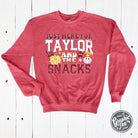 Heather Sport Scarlet crewneck sweatshirt featuring "Just Here For Taylor And The Snacks" graphic, by The Graphic Tee.