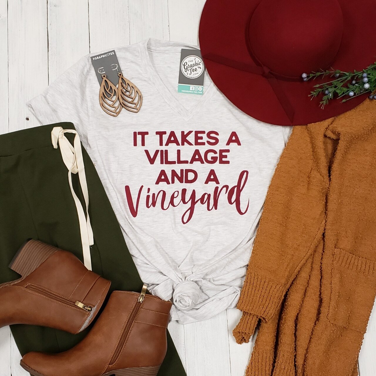 Unisex V-neck graphic tee featuring the "It Takes a Village and a Vineyard" design by The Graphic Tee, casual and comfortable.