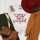 Unisex V-neck graphic tee featuring the "It Takes a Village and a Vineyard" design by The Graphic Tee, casual and comfortable.