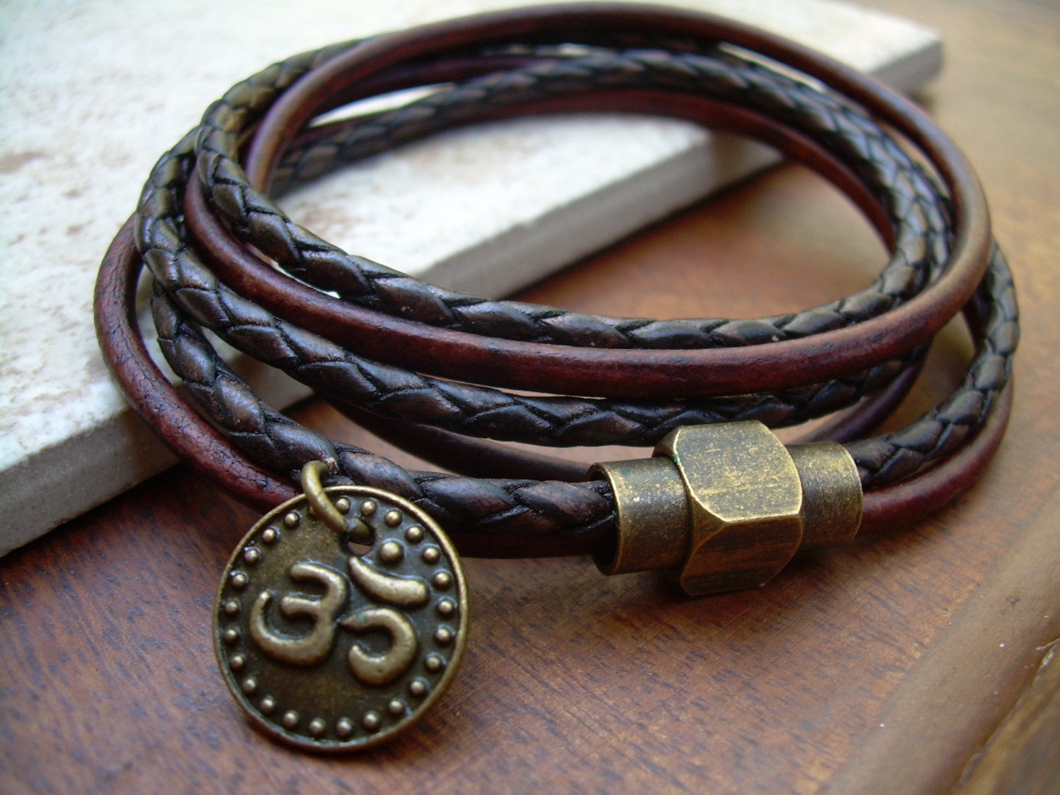 Dark brown leather bracelet with Om charm and antique brass magnetic clasp, triple wrap design from Urban Survival Gear USA.