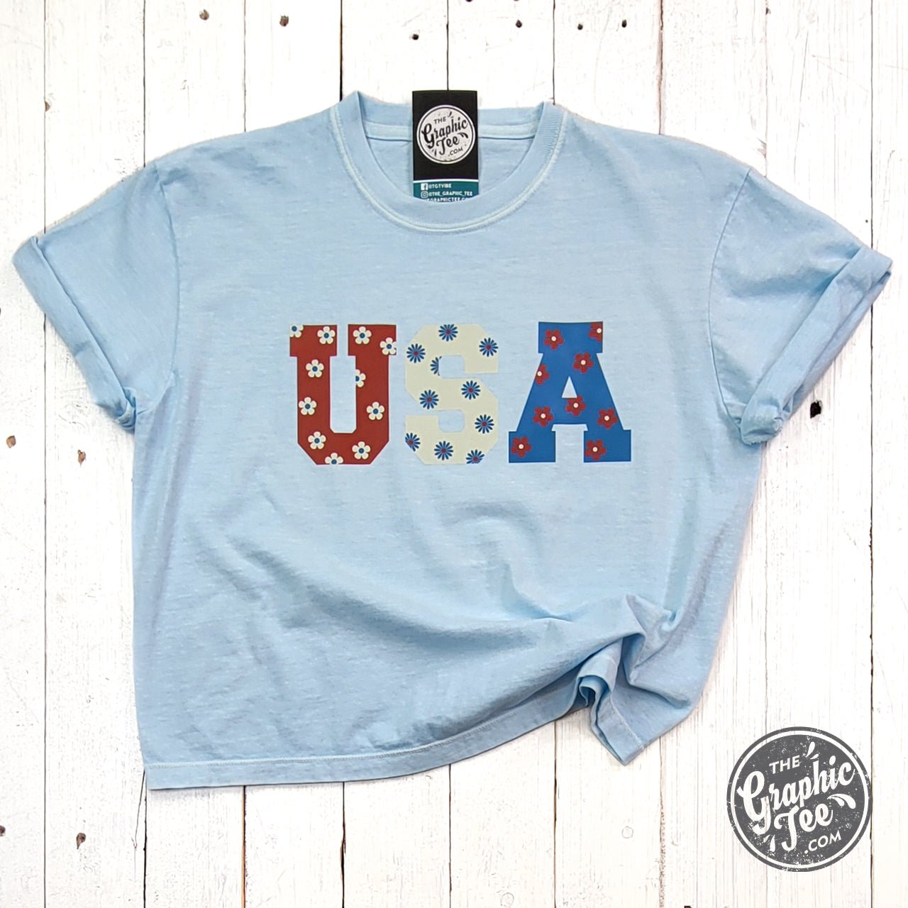 USA 90's inspired floral graphic SS tee by The Graphic Tee, mid-length pigment-dyed design with vibrant floral print.