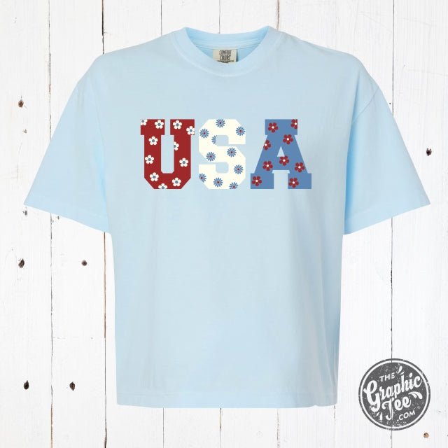 USA 90's inspired floral graphic mid-length pigment dyed tee by The Graphic Tee, showing vibrant floral design on soft fabric.