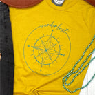 Short-sleeve graphic tee with wanderlust-themed design from The Graphic Tee, casual style perfect for travel and everyday wear.