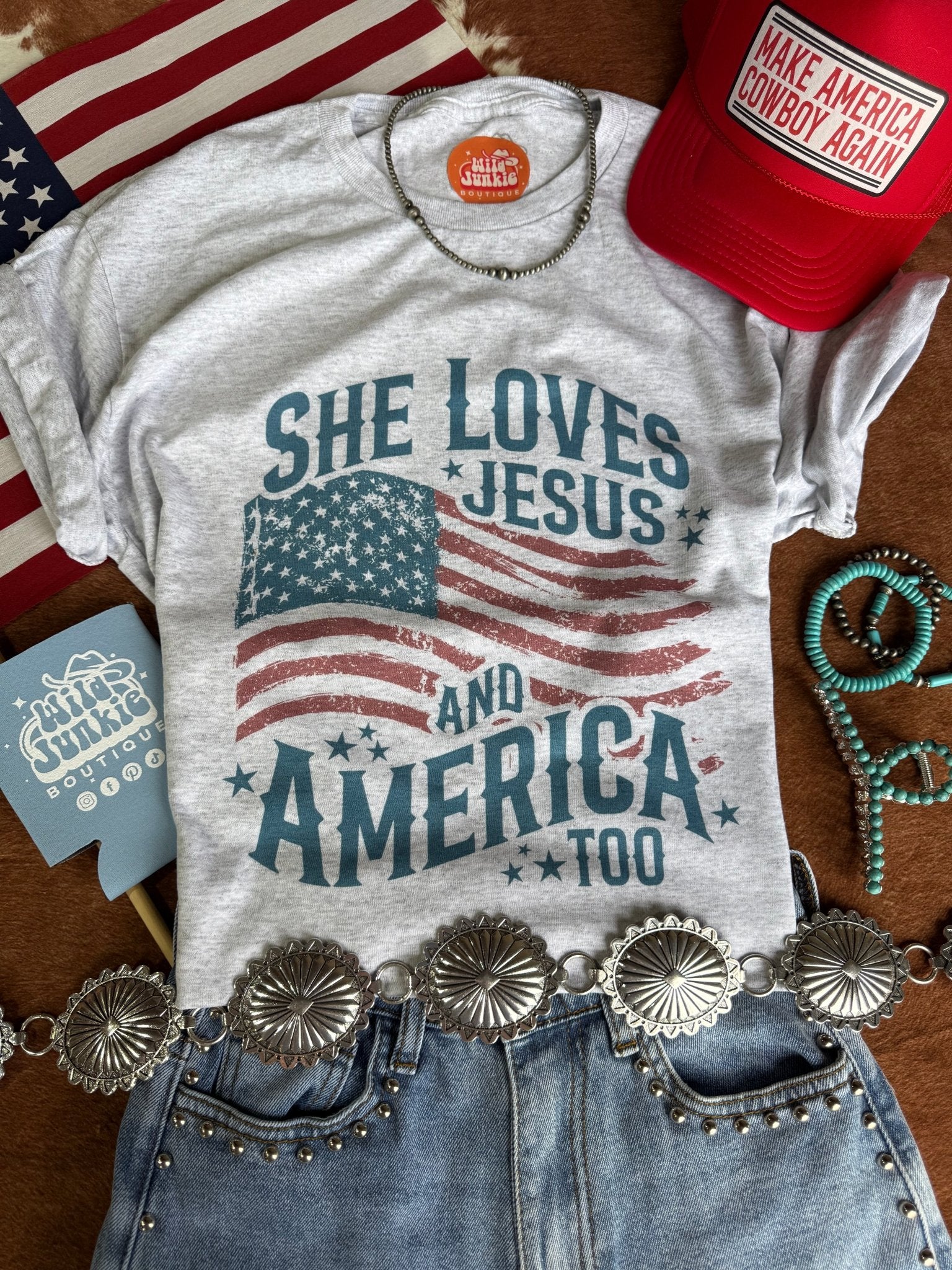 Wild Junkie She Loves Jesus & America graphic tee featuring bold design and patriotic imagery on soft cotton fabric.
