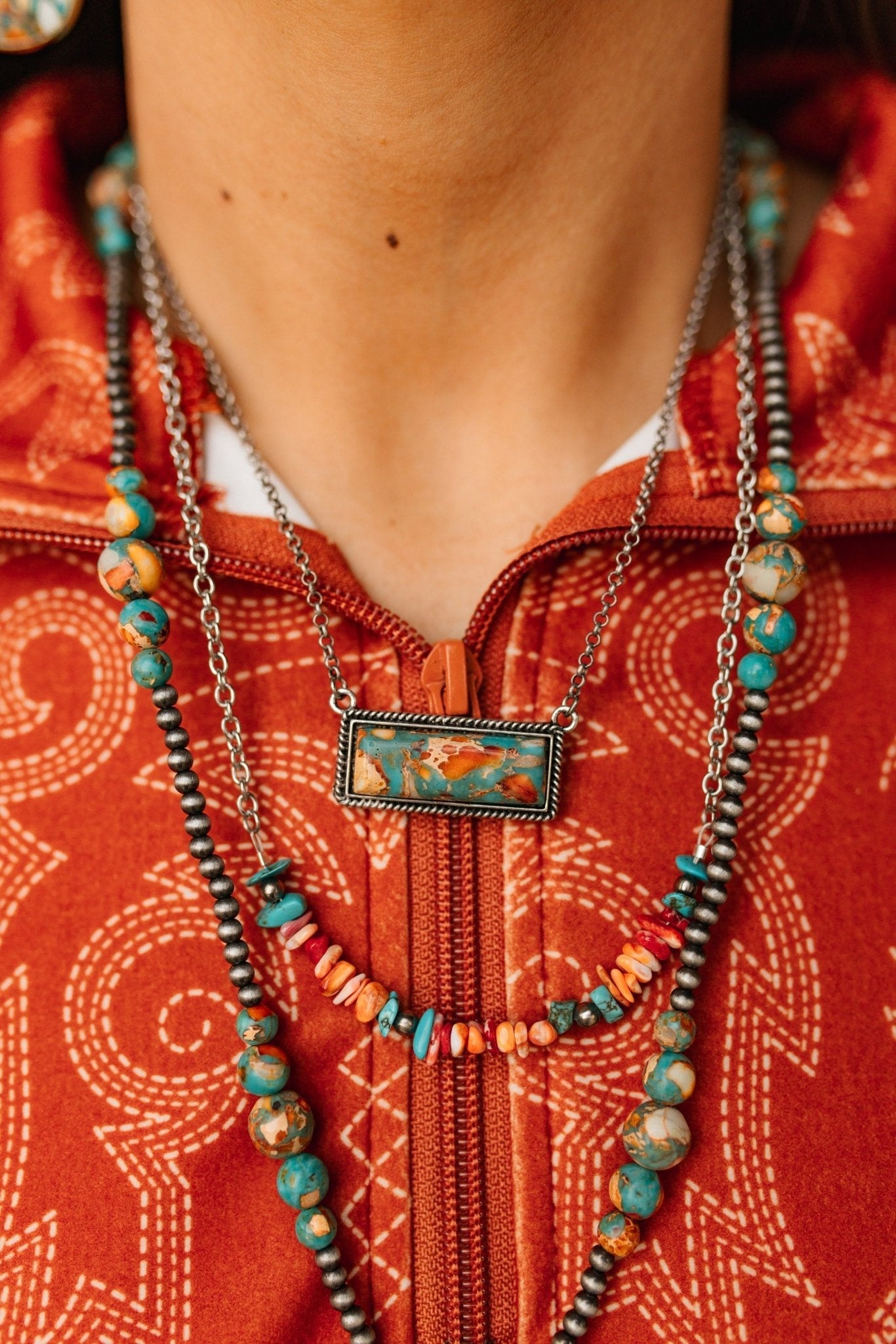 Authentic Spiny Oyster chip bead necklace by Wild Junkie featuring vibrant orange and red natural stone beads on a cord.