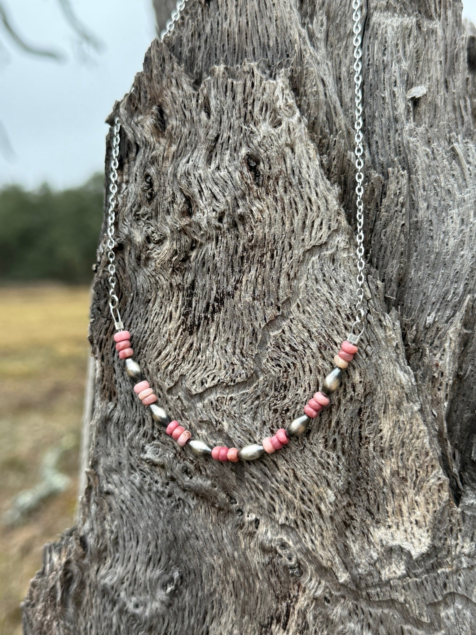 Pink Horizon Chain Necklace by Wild Junkie featuring a delicate pink chain with gold accents, styled on a neutral background.