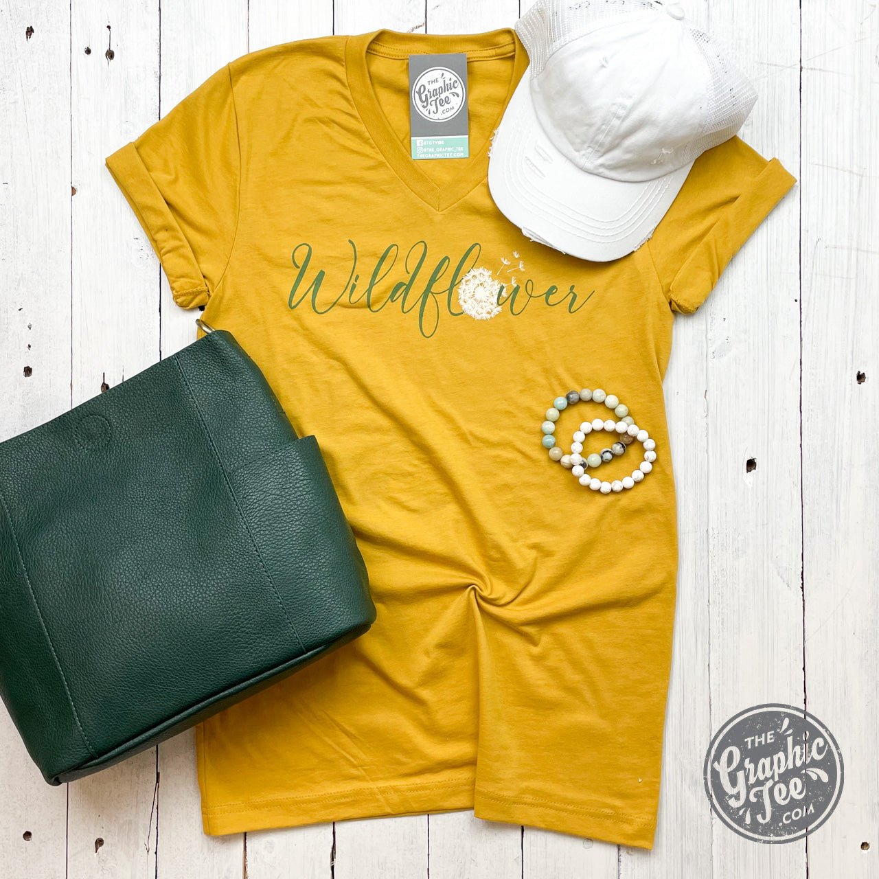 Wildflower Dandelion Mustard V-neck short sleeve graphic tee by The Graphic Tee, featuring floral design on a mustard-colored cotton shirt.